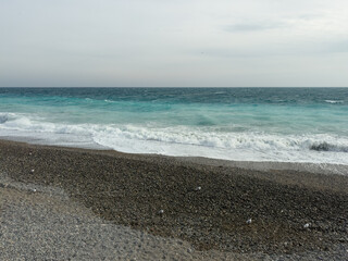 Pebble beach of Nice, France with azure waves of mediterranean sea