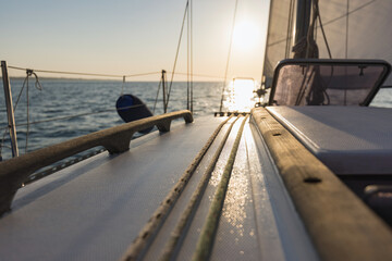Fototapeta na wymiar Sailboat yacht sailing in the sea at colorful sunset