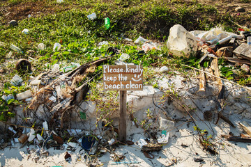 Sign saying "'Please kindly keep the beach clean"" and pile of different plastic and waste
