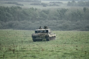 Naklejka premium Military tanks moving in a field