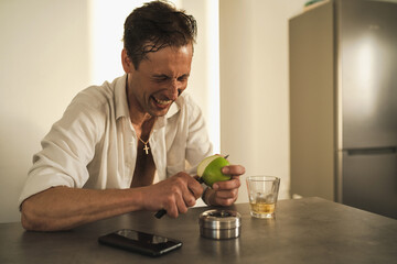 Portrait of handsome man cutting and eating apple