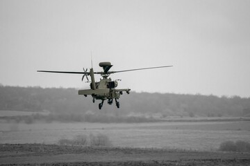 Fototapeta na wymiar Attack helicopter performing low level hover maneuver