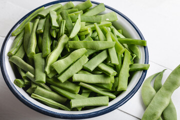 Fresh green beans in a bowl on a white wooden table. Bowl of green beans on wooden background. 