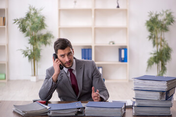 Young male employee and too much work in the office