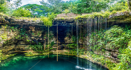 Panoramic view of the water falling from the waterfalls of the subway cenote Saamal of chichén itzá is in the Mayan jungle hacienda of the Yucatan Peninsula in Mexico it is an ideal place for vacation - obrazy, fototapety, plakaty