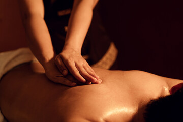 Masseuse hand massage aroma on back a man customer in cosmetology spa centre. - obrazy, fototapety, plakaty