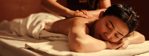 Obraz na płótnie Canvas Relaxation Asian woman customer get service aromatherapy massage with masseuse in spa salon.