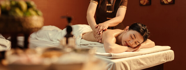 Relaxation Asian woman customer get service aromatherapy massage with masseuse in spa salon.