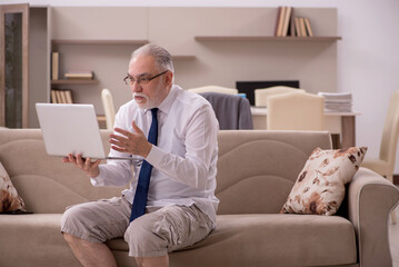 Old male employee working from home during pandemic