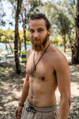 Portrait of young bearded man with naked torso