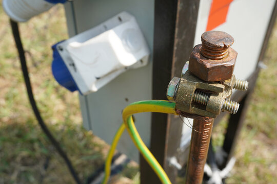 Close-up of copper electrical grounding rods into the ground on the site construction project to prevent short circuits. Selective focus