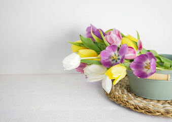 yellow, white, pink and purple tulips on white wooden ground with space for text, background
