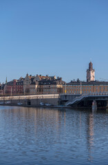 Fototapeta na wymiar A bridge at the old town Gamla Stan and the church Tyska kyrkan, a sunny spring morning in Stockholm