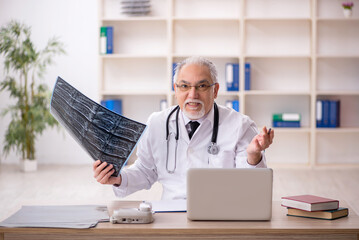 Old male doctor radiologist working in the clinic