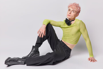 Full length shot of handsome pink haired man has non traditional orientation dressed in green net...