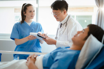 Fototapeta premium Doctor and nurse examining patient's medical records and medical team working.