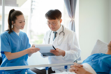 Obraz premium Doctor and nurse examining patient's medical records and medical team working.