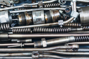 Steel mechanical parts smeared with machine oil, close-up. Steel nozzles, springs, studs, couplings and tubes.