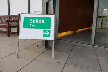 A Little Sign Board to Show Exit Way Both in English and Spanish (Bilingual)