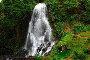 person photographing beautiful waterfall in the azores