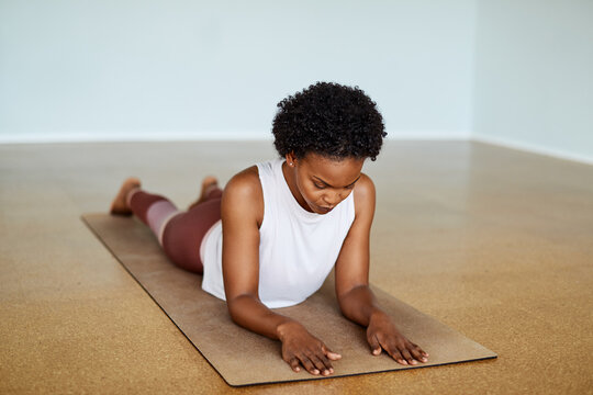 Young woman practicing the sphyinx pose during a yoga class