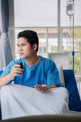 Patient sitting on bed and looking out window in hospital and having stress, boredom, loneliness, anxiety, healthcare and medical.