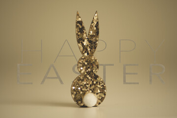 Golden glitter rabbit, background gold with lettering in the background happy easter