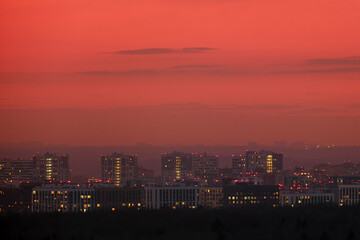 Naklejka premium Night city with illumination of windows of houses. Buildings with light in residential apartments