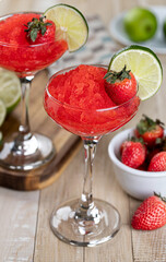 Frozen strawberry daiquiri cocktail with strawberries and lime