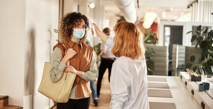 Businesswoman reading a colleague's temperature
