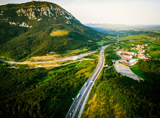 Aerial dramatic view Slovenian motorway road with lorry and cars with green meadow summer fields...