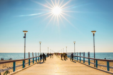 Palanga, Lithuania - 6th June, 2021: Palanga pier with tourists walking in heat in sunny summer day. Lithuania holiday destination.