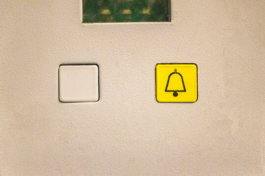 Two elevator buttons: an empty and a yellow emergency button to rescue
