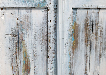 Close-up of antique white wooden cabinet with distressed paint texture and vintage hardware