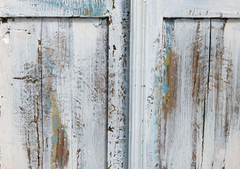 Close-up of antique white wooden cabinet with distressed paint texture and vintage hardware