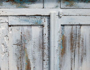 Vintage white wooden cabinet with distressed paint texture and aged hardware, close-up shot