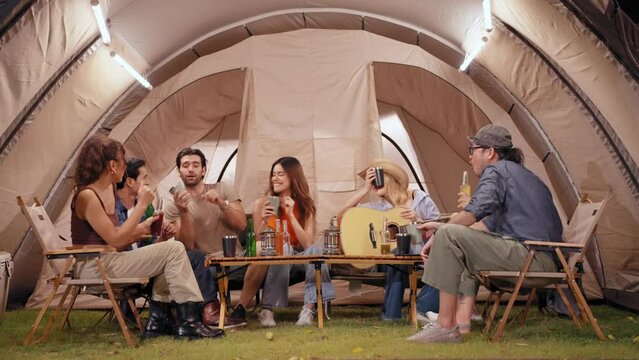 Happy young friends traveler group having fun music together in camping party, Group of multiculturalism hipster people enjoying holiday vacation trip in campsite