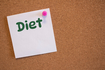 White square sticker with a diet note pinned to a cork board