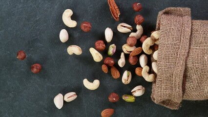 Super slow motion of falling mix nuts in jute bag. Filmed on high speed cinematic camera at 1000 FPS.
