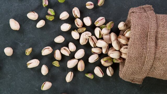 Super slow motion of falling pistachios nuts in jute bag. Filmed on high speed cinematic camera at 1000 FPS.