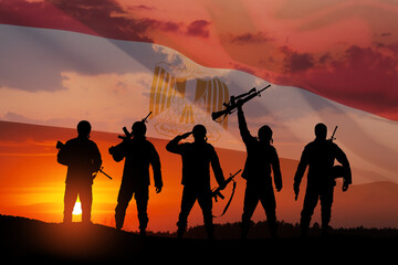 Double exposure of silhouettes of a soliders and the sunset or the sunrise against flag of Egypt.