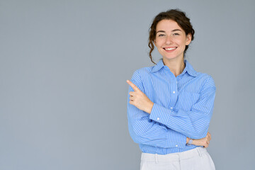 Happy young smiling professional business woman wearing blue shirt looking at camera pointing...