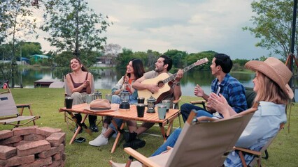 Happy young friends traveler group having fun music and dancing together in camping party, Group of multiculturalism hipster people enjoying holiday vacation trip in campsite