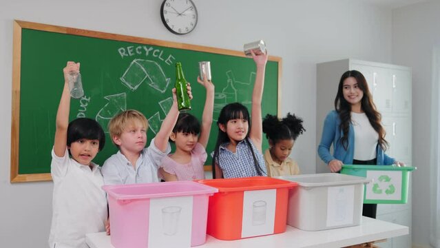 Teacher woman is teaching a class on selecting and separating waste for recycling, Student with recycle trash in classroom at elementary school