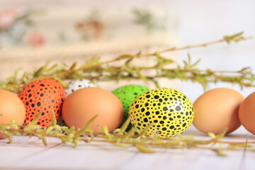 Easter eggs close-up on a wooden table and willow twigs. Painted Easter eggs are a traditional symbol of a religious holiday. Christian traditions of celebration