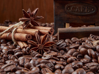 Antique vintage retro bronze coffee mill on black wooden board with roasted coffee beans