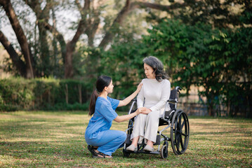 Elderly asian senior woman on wheelchair with Asian careful caregiver.