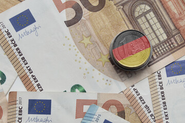 euro coin with national colorful flag of germany on the euro money banknotes background