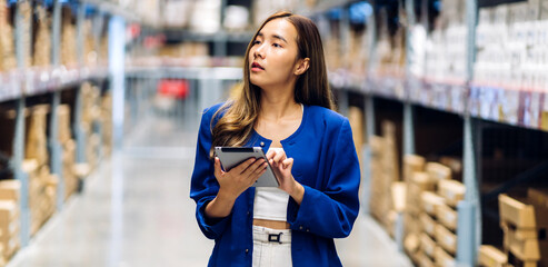 Portrait engineer asian woman shipping order detail on tablet check goods and supplies on shelves...