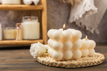 Cozy decor and burning candles against the backdrop of a minimalist interior. Trendy Bubble candles with vanilla flavor. Eco soy candles. Candles for relaxation. Close-up. Place for text. Interior. Hy